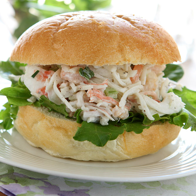 Sandwich de pan francés con ensalada de verduras y cangrejo.
